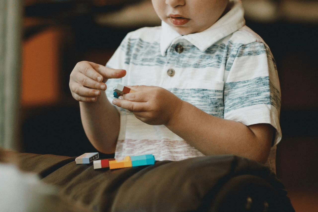 A child concentrating while building with colourful blocks